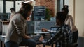 Programer sitting on desk discussing with mixed team of software developers about artificial intelligence