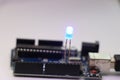 Programmable micro controller board controlling illumination of LED bulb. Open source Arduino micro controller with LED Royalty Free Stock Photo