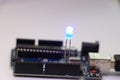 Programmable micro controller board controlling illumination of LED bulb. Open source Arduino micro controller with LED