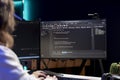 Programmer in apartment solving coding problems using desktop PC