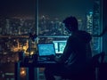 Programmer with coding on a computer in the dark with a view of the lights of the night city. developer or hacker