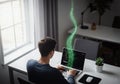 Programmer coding on a laptop with a glowing stream of data rising from the screen Royalty Free Stock Photo