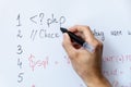 Programmer education and web development - hand with marker writing php programming code on whiteboard Royalty Free Stock Photo