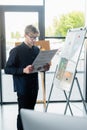 Programmer in eyeglasses holding document near