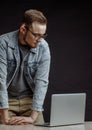 Programmer in fashin clothes standing and leaning on his palms