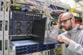 Programmer with glasses made a mistake when working in the server room. The system administrator took his hand to the head in the