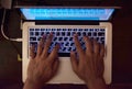 Programmer hands on the illuminated keyboard of laptop. Top view