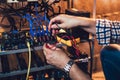 Programmer holding a wattmeter measuring cryptocurrency mining rig