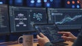 Programmer working on multiple computer screens displaying code and data analysis Royalty Free Stock Photo