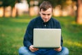 Programmer working in the park on laptop. Man sitting on bench Royalty Free Stock Photo