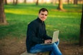 Programmer working in the park on laptop. Man sitting on bench Royalty Free Stock Photo