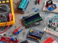 Programmers and Arduino with peripherals and expansion boards lie on a gray background. Do-It-Yourself
