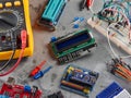 Programmers and Arduino with peripherals and expansion boards lie on a gray background
