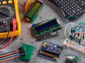 Programmers and Arduino with peripherals and expansion boards lie on a gray background. Do-It-Yourself