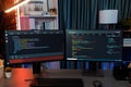 Programming code on computer two screen on desktop at neon light room. Infobahn. Royalty Free Stock Photo