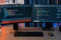 Programming code on computer two screen on desktop at neon light room. Infobahn. Royalty Free Stock Photo