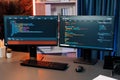 Programming code on computer two screen on desktop at neon light room. Infobahn. Royalty Free Stock Photo