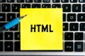 programming language inscription `HTML` on a yellow sheet of sticker paper on the background of a computer keyboard Royalty Free Stock Photo