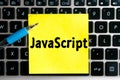 programming language inscription `JavaScript` on a yellow sheet of sticker paper on the background of a computer keyboard Royalty Free Stock Photo