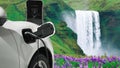 Progressive concept of energy sustainability by EV car in the waterfall.