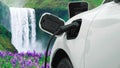 Progressive concept of energy sustainability by EV car in the waterfall.