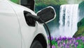 Progressive concept of energy sustainability by EV car in the waterfall.