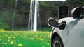 Progressive concept of energy sustainability by EV car in the waterfall.