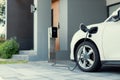 Progressive concept of EV car and home charging station in residential area.