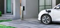 Progressive concept of EV car and home charging station in residential area. Royalty Free Stock Photo