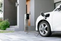 Progressive concept of EV car and home charging station in residential area. Royalty Free Stock Photo