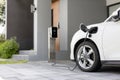 Progressive concept of EV car and home charging station in residential area. Royalty Free Stock Photo
