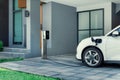 Progressive concept of EV car and home charging station in residential area.