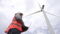 Progressive engineer working with the wind turbine, with the sky as background. Royalty Free Stock Photo