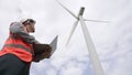 Progressive engineer working with the wind turbine, with the sky as background. Royalty Free Stock Photo