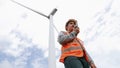 Progressive engineer working with the wind turbine, with the sky as background. Royalty Free Stock Photo