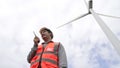 Progressive engineer working with the wind turbine, with the sky as background. Royalty Free Stock Photo