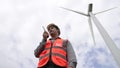 Progressive engineer working with the wind turbine, with the sky as background. Royalty Free Stock Photo