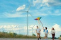 Progressive happy carefree family vacation concept flying kite with wind turbine Royalty Free Stock Photo