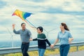 Progressive happy carefree family vacation concept flying kite with wind turbine Royalty Free Stock Photo