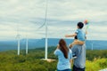 Progressive happy family enjoy their time at wind farm for green energy concept. Royalty Free Stock Photo