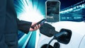 Progressive man charge electric car with technology background of binary code. Royalty Free Stock Photo