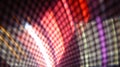 Progressive rhythmic red shaded light layers seen through a net fence pattern