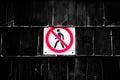 Prohibition No Pedestrian Sign next the fence. Prohibited signs figura of walking man in a crossed circle on black background
