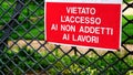 Prohibition sign in red background and white writing with written in Italian FORBIDDEN ACCESS TO NON-WORKERS on metal grating Royalty Free Stock Photo