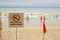 Prohibitive sign No Swimming and red flag at a beach