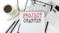 PROJECT CHARTER text on the paper with calculator, notepad, coffee ,pen with graph Royalty Free Stock Photo
