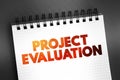 Project evaluation - systematic and objective assessment of an ongoing or completed project, text on notepad, concept background Royalty Free Stock Photo