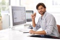 The project is looking good. a handsome man working on a computer in an office. Royalty Free Stock Photo