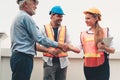 Project management team of engineers and architects are handshake together after dealing their project, Business construction con