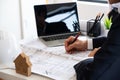 Project manager inspecting a building plan on his laptop